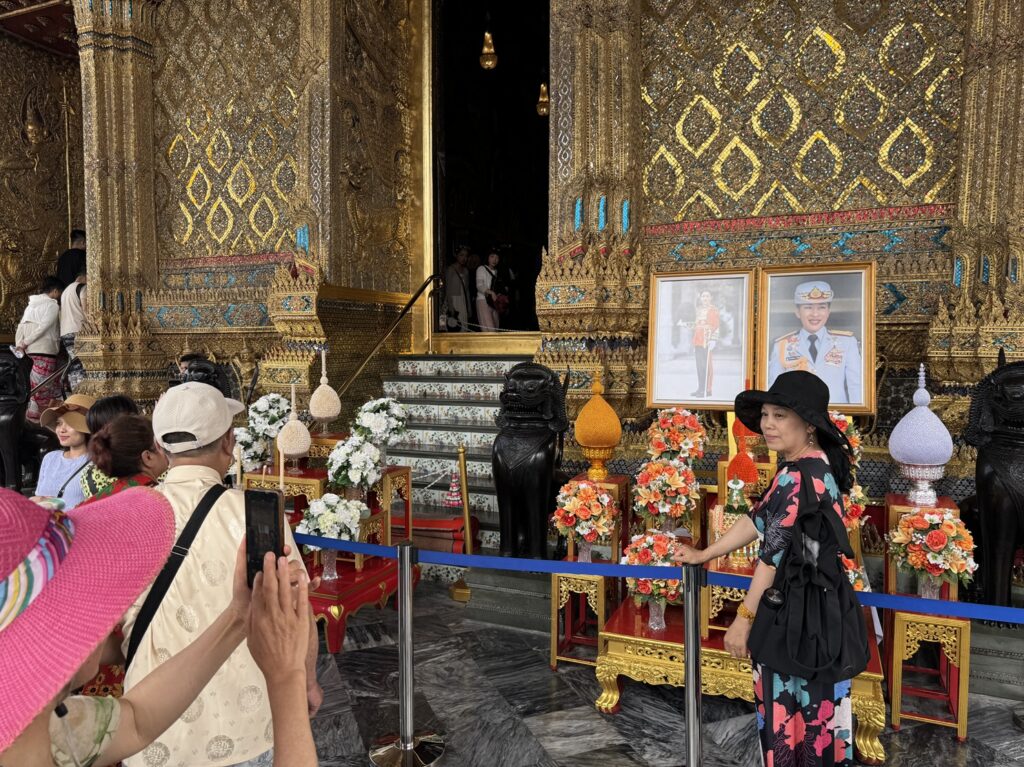 Une Thaïlandaise pose devant des photos de la reine Suthida de Thaïlande